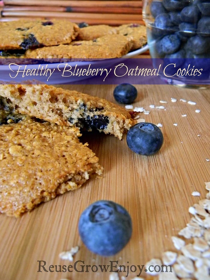 Wood cutting board with blueberry oatmeal cooking cut in half. Fresh blueberries around and plate of cookies in background