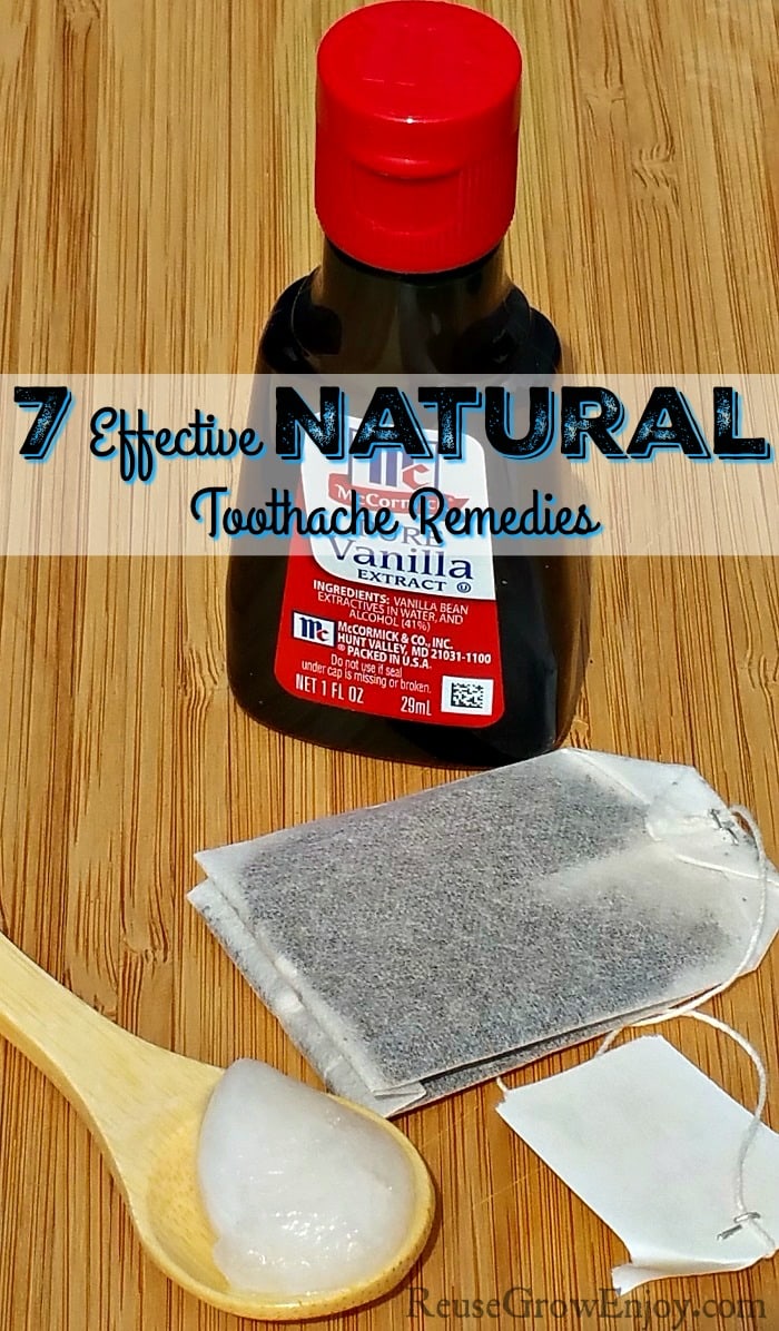 Vanilla, spoon of coconut oil and a tea bag laying on wood. Text overlay that says "7 Effective Natural Toothache Remedies" in the middle