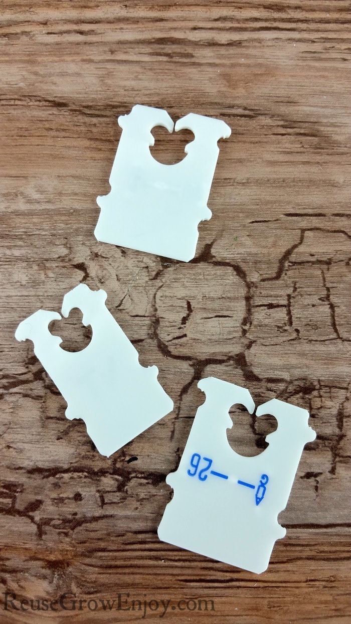 3 white Bread clips laying on wood looking background