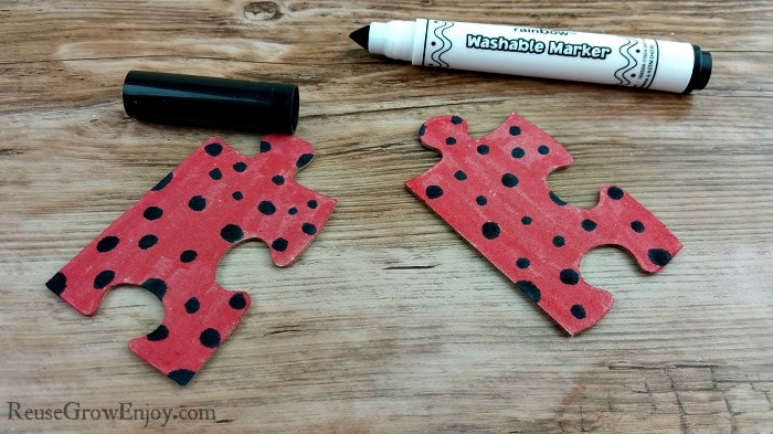 Add black spots to the red puzzle pieces.