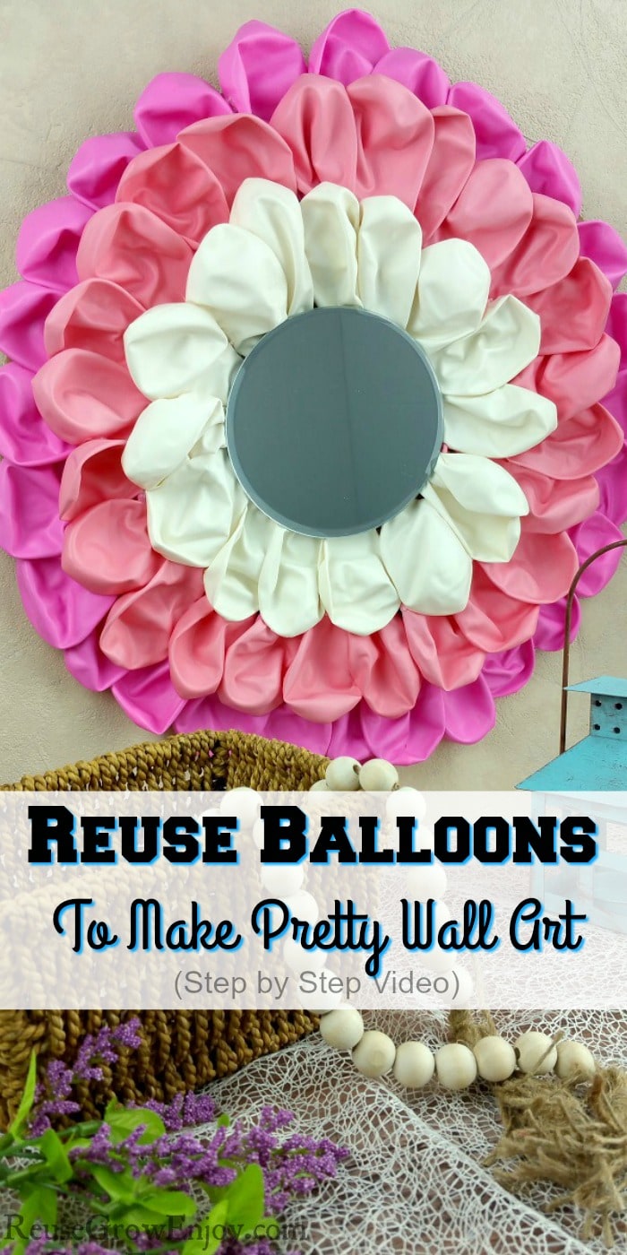 Balloon craft wall art hanging on wall with mirror in center. Small basket with beads in front and a candle holder on right. Text overlay that says "Reuse Balloons To Make Pretty Wall Art".