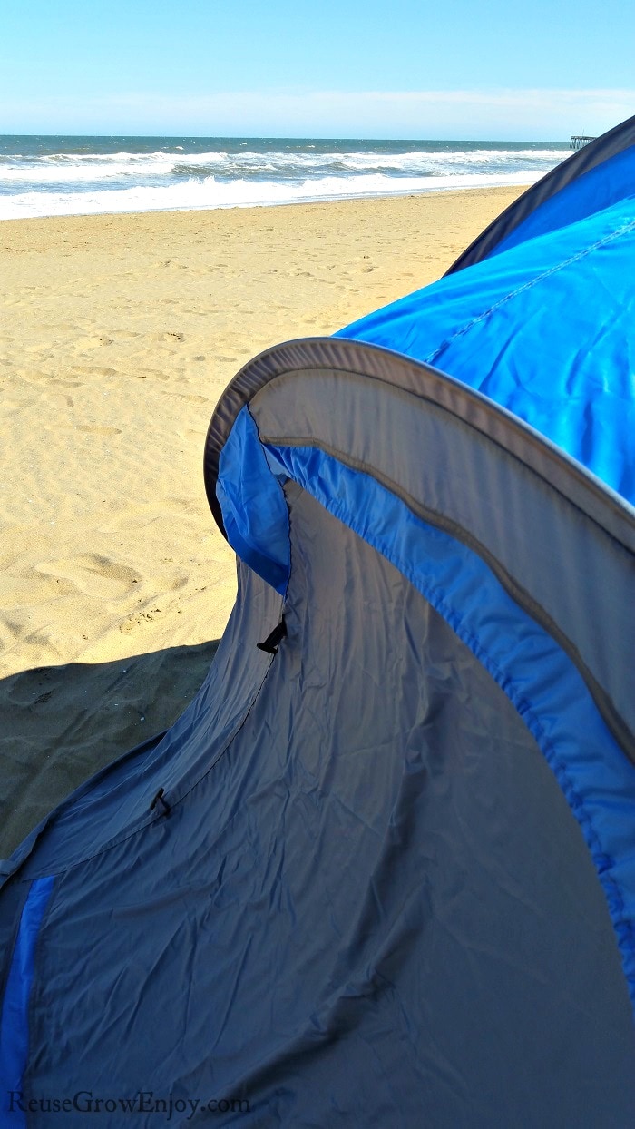 Tent on the beach with ocean in background.