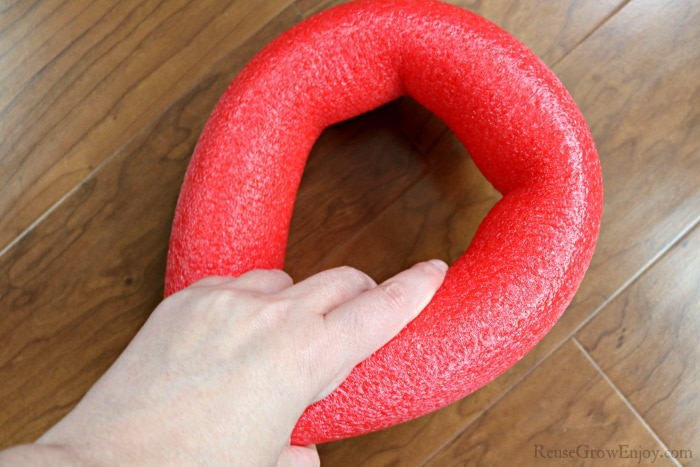 Hand bending pool noodle to make curve