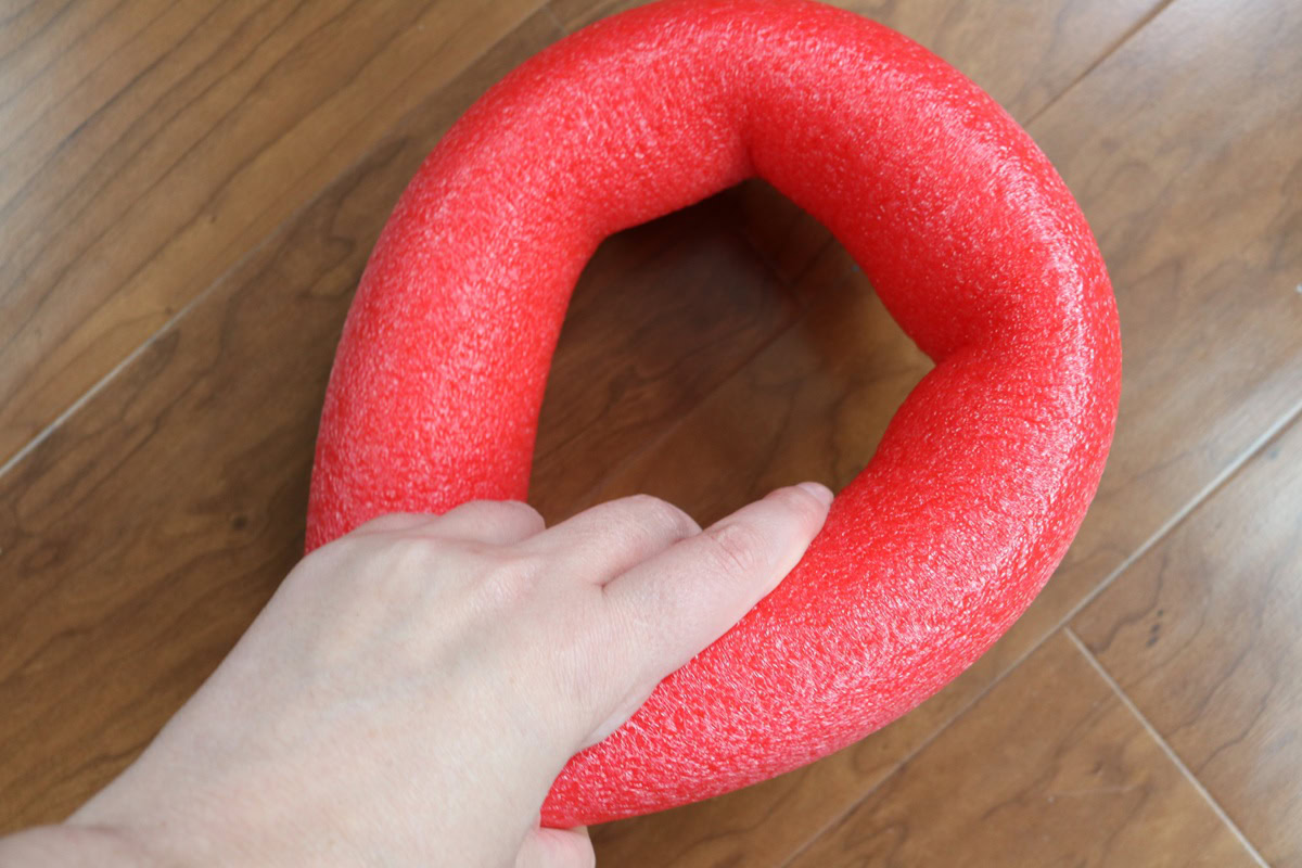 Large red pool noodle shaped like a candy cane for DIY craft projects.
