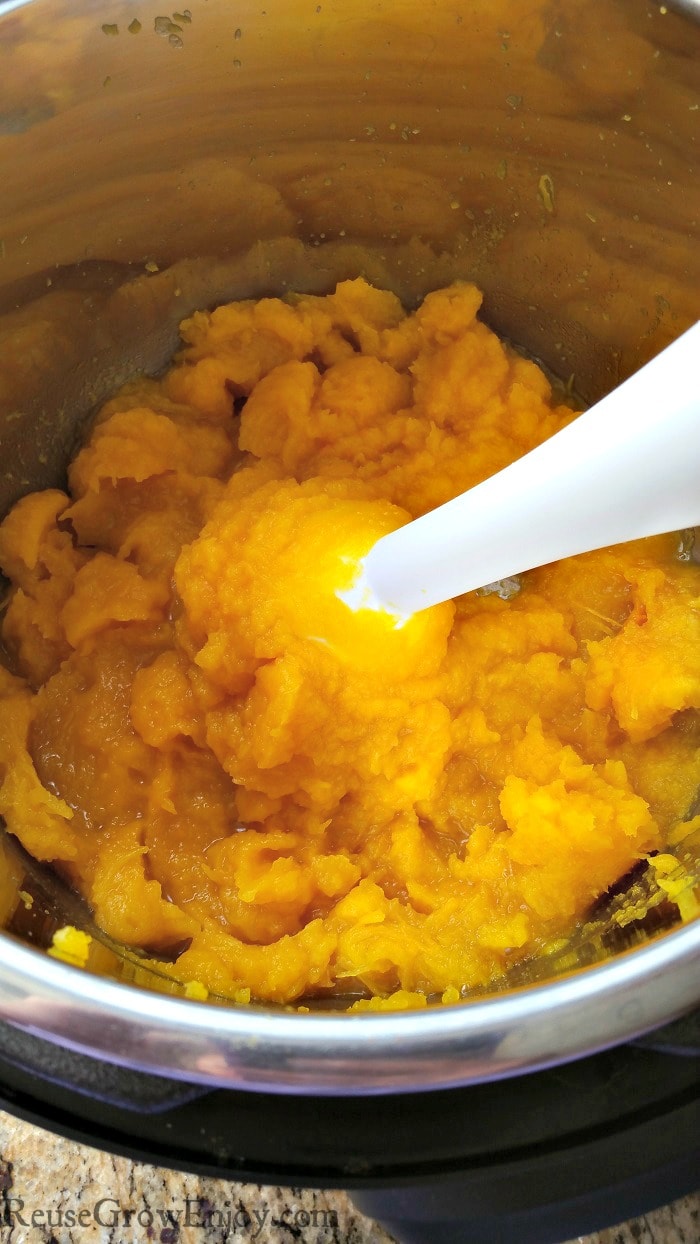 White hand blender mixing pumpkin puree in the Instant Pot.
