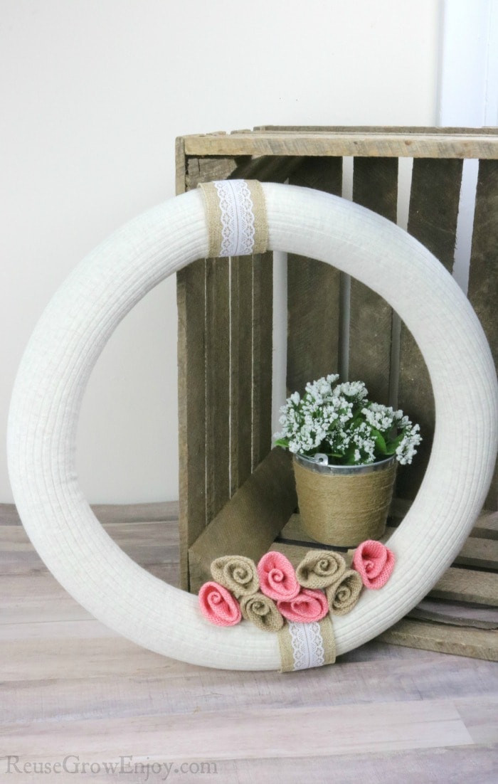 Finished wreath with wood crate and white flower in background