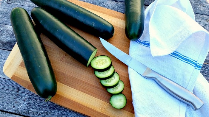 Sliced cucumbers on wood cutting board with knife. Grow Cucumbers In The Garden