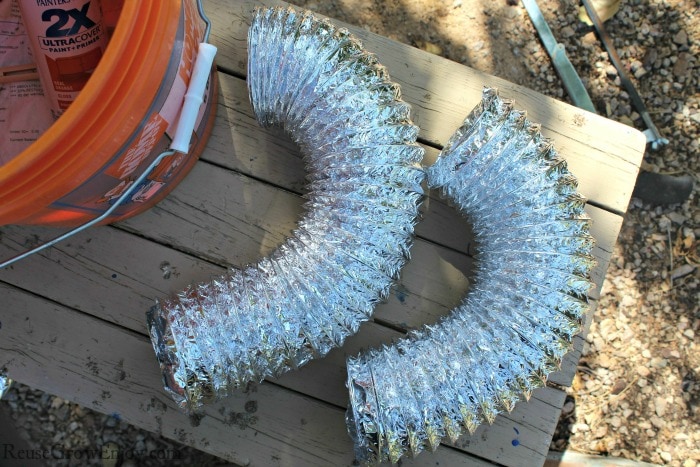 Two pieces of dryer duct laying on table.