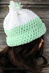 Green and white crochet hat on top of head