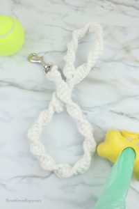 Finished white leash with ball and doggy bag holder to the side