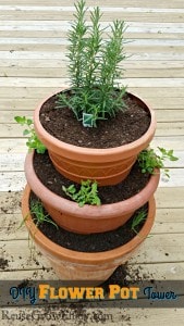Three pots of different sizes stacked on top of each other with plants. Text overlay at the bottom that says DIY Flower Pot Tower