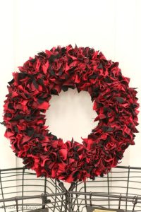 Red and black fabric wreath laying on wire baskets