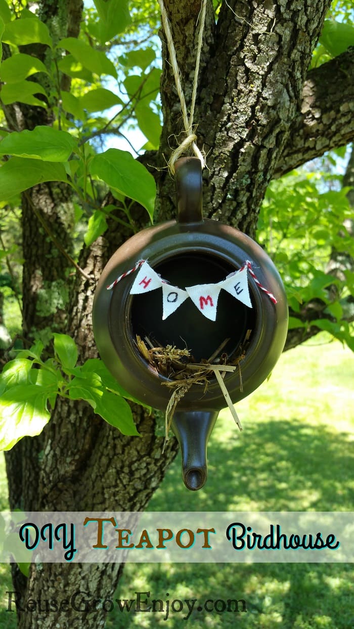 Brown tea pot birdhouse hanging from tree
