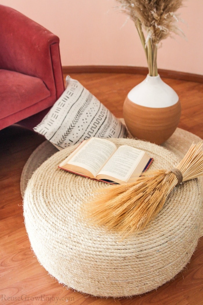 Finished tire table/ottoman with dried wheat and a book on it.