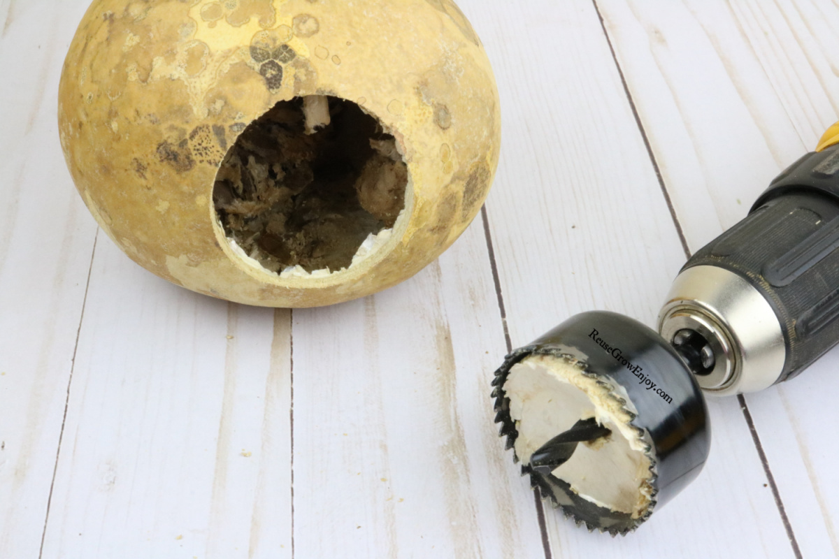 Large hole drilled in the side of the gourd with drill to the side