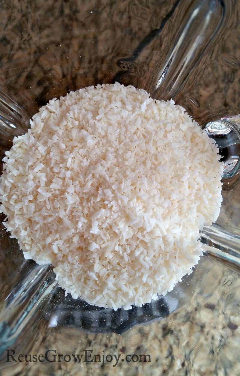 Dry coconut shreds in a glass blender.