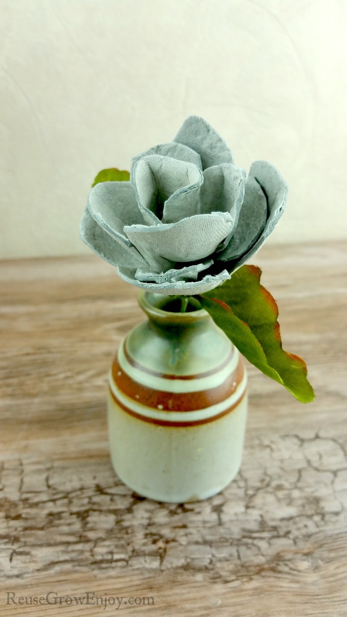 A rose made from egg cartons standing in a jug vase.