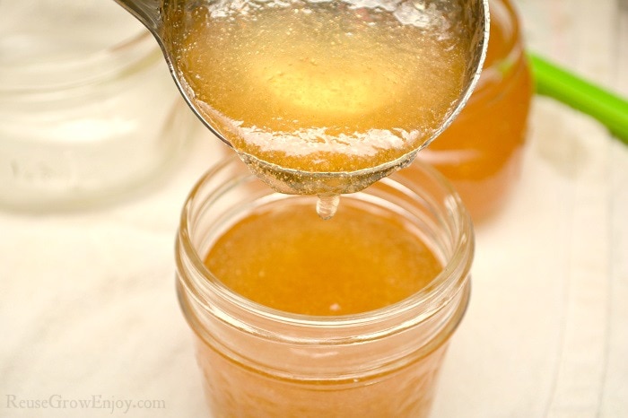 Spoon filling jars with loquat jelly.