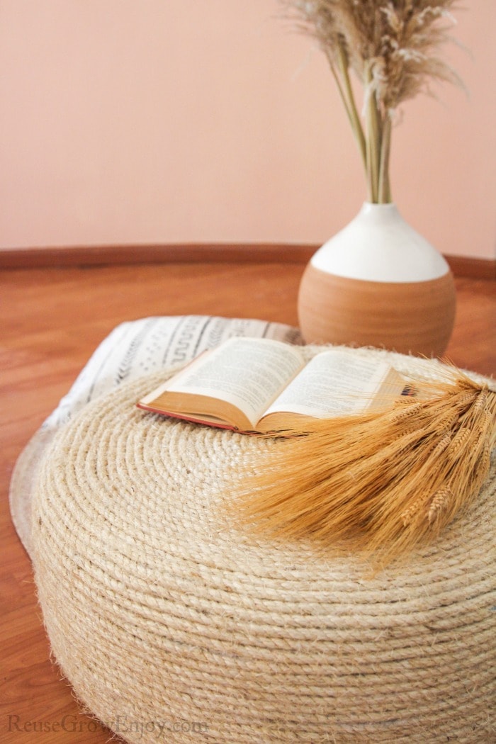 Finished tire ottoman with book and wheat on top