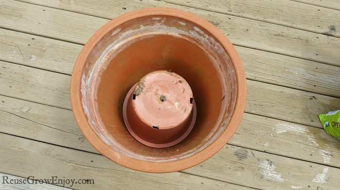 Large empty flower pot with smaller pot turned upside down inside larger pot