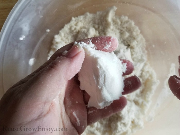 Hand making a ball from bath bomb mixture