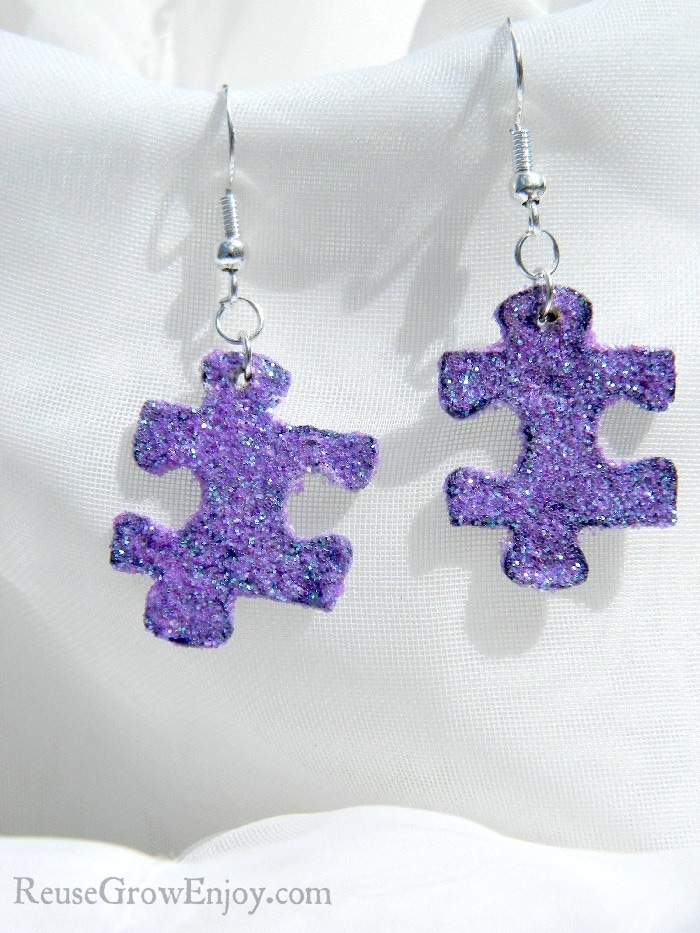 There are lots of different ways you can reuse puzzle pieces. One way that I am going to show you is to make glitter upcycled puzzle piece earrings.