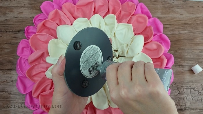 Hand gluing mirror in center of balloons.