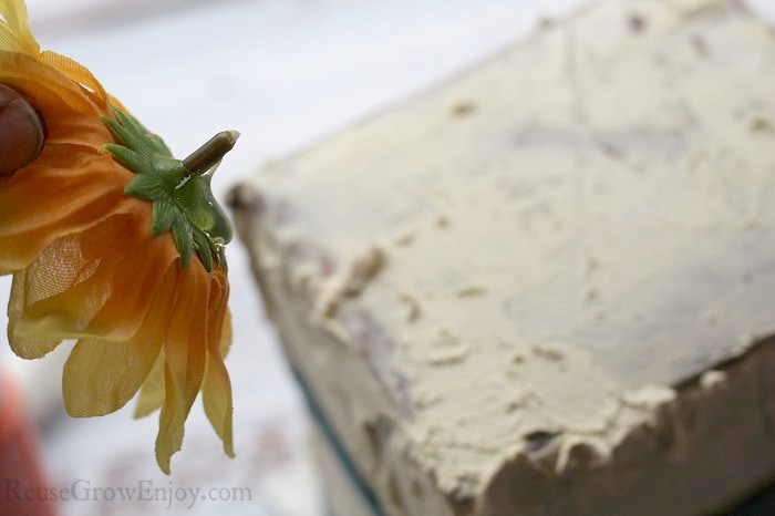 Hot gluing sunflowers to box.