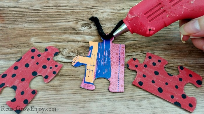 Glue pipe cleaner to back of black puzzle piece