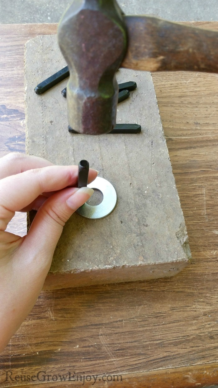 Hand holding stamp on washer