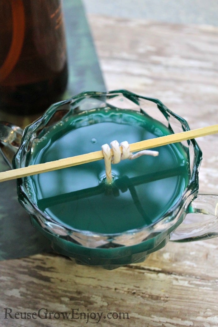 Pour the wax in the jar and be sure to hold the wick centered and above the top of the wax