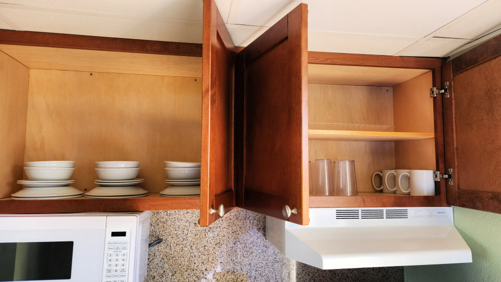 Open cabinets in kitchen with glasses and dishes