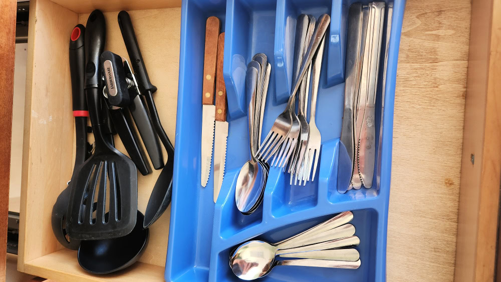 Drawer in kitchen with forks spoons and knives