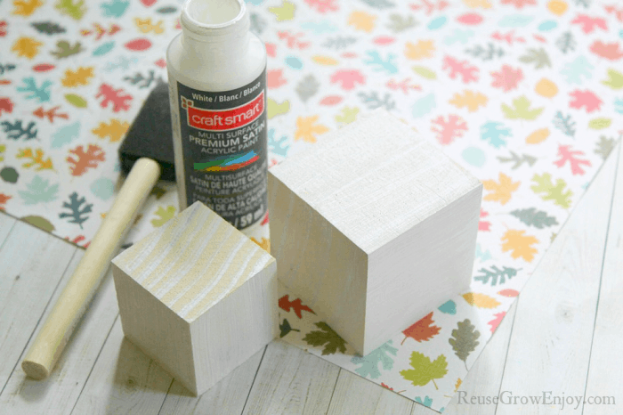 Wood blocks after one coat of white paint. Paint in background.