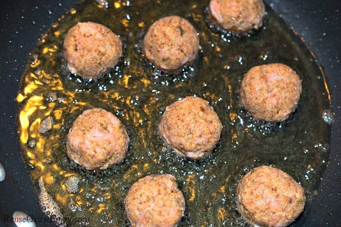 Mixture made into fish balls and being cooked in a hot pan of oil