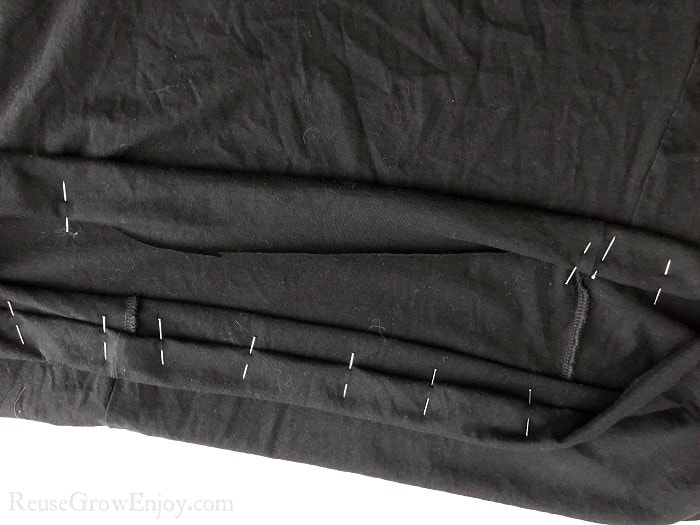 Stick pins being places around the fold on the black skirt.