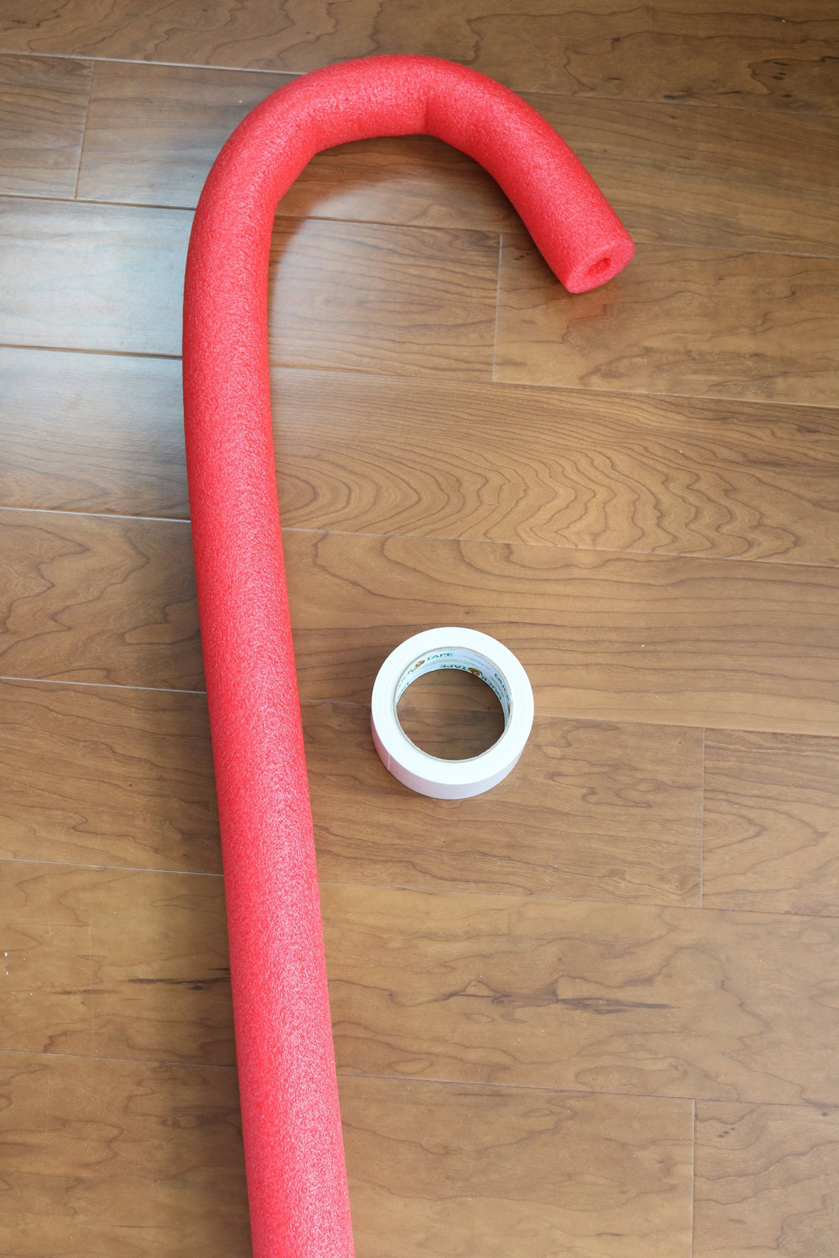 Red pool noodle shaped like a giant candy cane for holiday decor.