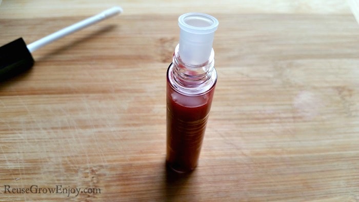 After you have made the tinted natural lip gloss, you need to push the scraper plug into the bottle before putting the top on.