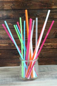 Glass jar full of all different colors and sizes of plastic straws