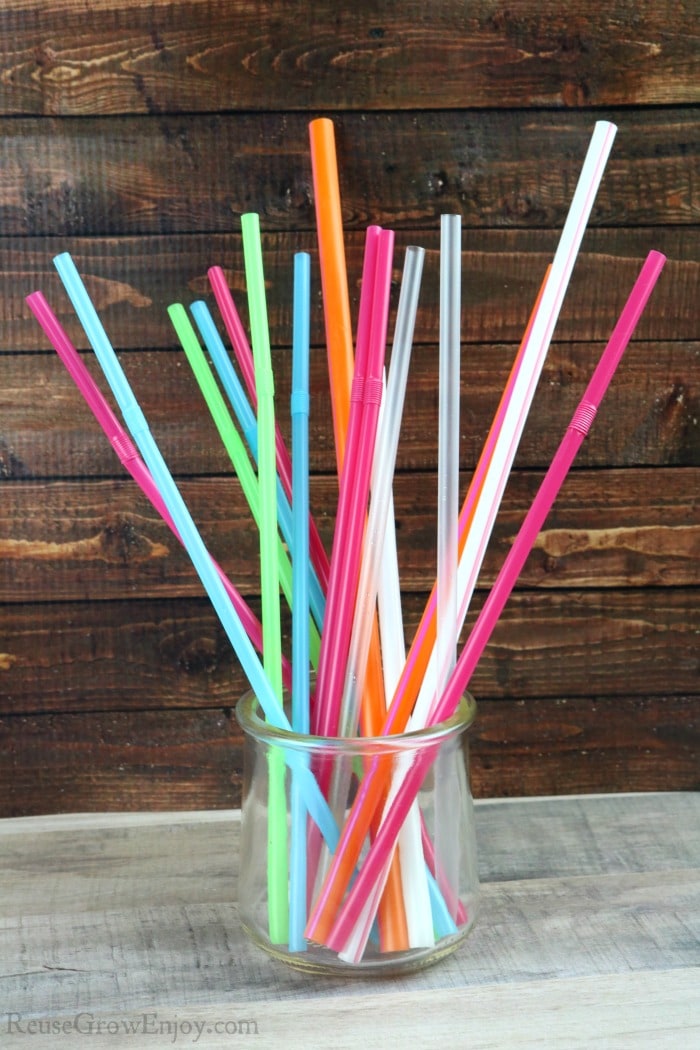 Glass jar full of all different colors and sizes of plastic straws