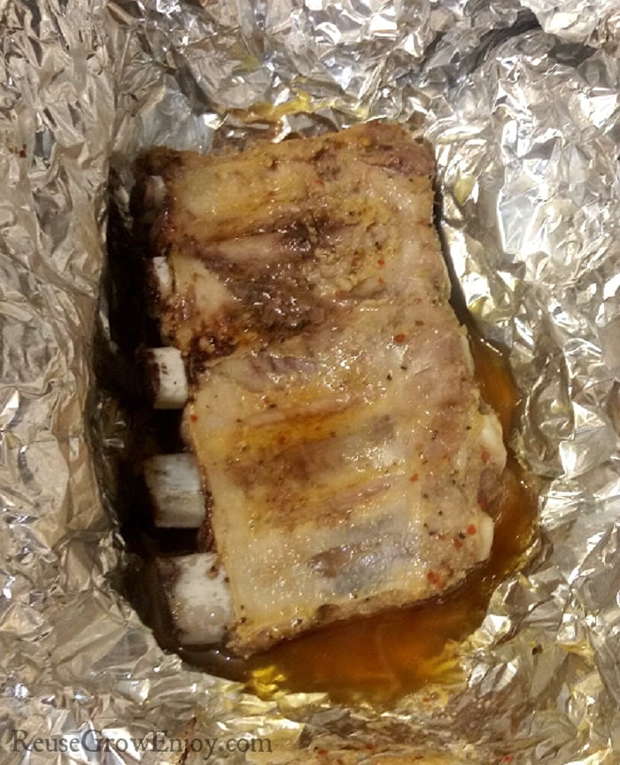 Ribs cooked in foil with the juice at the bottom.