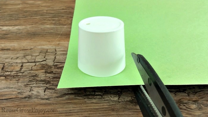 Scissors cutting green paper