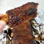Single cooked rib being held