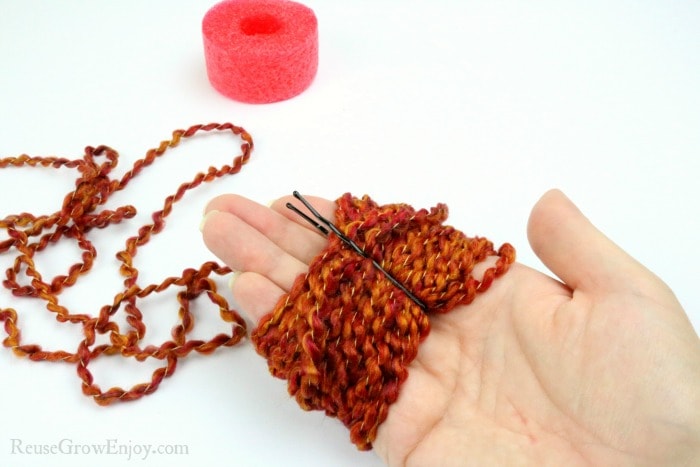 Slide pin over yarn