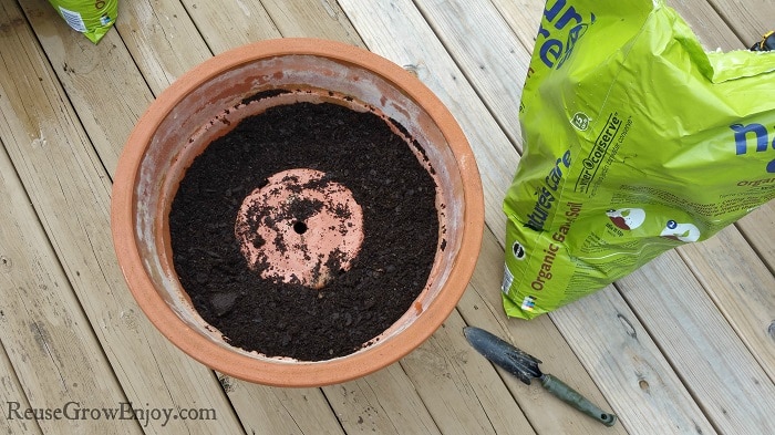 Dirt filled in around upside down pot in larger pot