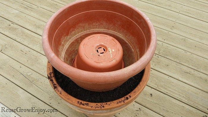 Smaller pot sitting on upside down pot in larger. Also has a smaller pot upside down in the top pot 