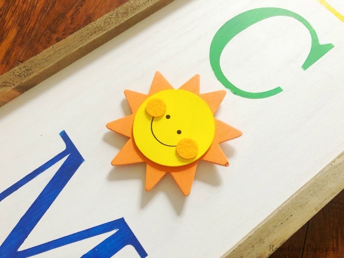 Wood sun attached to welcome sign