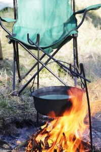 Folding chair by campfire with dutch oven