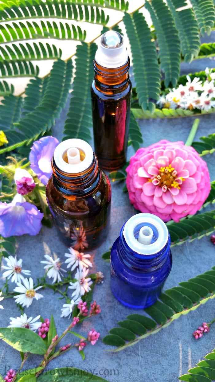 Bottles of Essential Oils for Fibromyalgia with bright pretty flowers all around