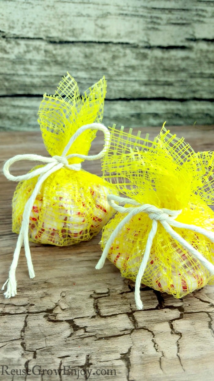 Yellow mesh produce bags made into treat bags with wood background.